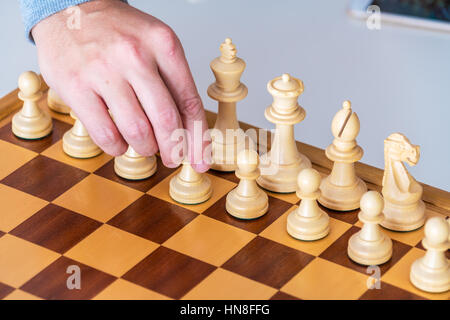 Der Anfang des Spiels - macht die Hand mit dem Bauern den ersten Schritt auf die Chess Board Stockfoto