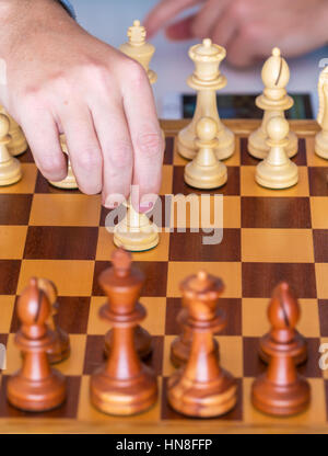 Der Anfang des Spiels - macht die Hand mit dem Bauern den ersten Schritt auf die Chess Board Stockfoto