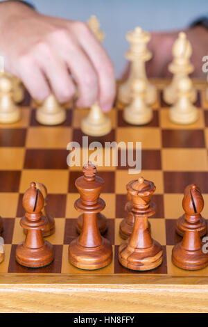 Der Anfang des Spiels - macht die Hand mit dem Bauern den ersten Schritt auf die Chess Board Stockfoto