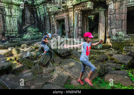 Kinder spielen in der Mitte Tempelruinen im Innenhof von der Ta Prohm Verbindung in Siem Reap, Kambodscha. Stockfoto