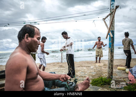 Fischer reparieren Angelschnur am Strand des Malabro-Dorfes in Bengkulu, einer Stadt an der Westküste Sumatras mit Blick auf den Indischen Ozean. Archivbild. Stockfoto