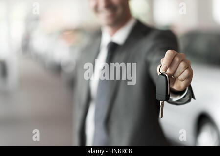 Lächelnde Autoverkäufer Übergabe Ihres neuen Autoschlüssel, Autohaus und Vertriebskonzept Stockfoto