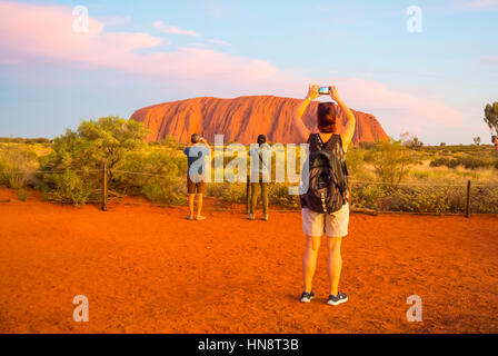 Touristen schnappen sich den Sonnenuntergang Ayers Rock Australia Stockfoto