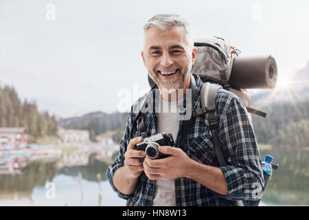 Wanderer in den Bergen wandern und Fotografieren mit seiner Kamera und fröhlich Fotograf Stockfoto