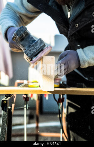 Männer, die einige Holzarbeiten, ein Holz mit Sander Schleifen Stockfoto