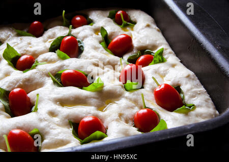 Kochen Pizza. Italienische Focaccia Teig auf dem Backblech. mit Cherry-Tomaten und Basilikum. traditionelle Küche. Stockfoto