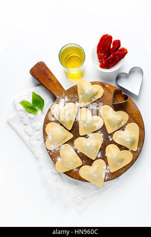 frische italienische Ravioli in Form von Herzen. Essen-Hintergrund. auf weiß Stockfoto