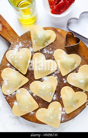 frische italienische Ravioli in Form von Herzen. Essen-Hintergrund. auf weiß Stockfoto