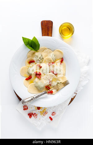 Essen in Herzform. köstlichen Ravioli. frisch hausgemacht. gekocht. in einem weißen Teller. mit Basilikum und Olivenöl. Stockfoto