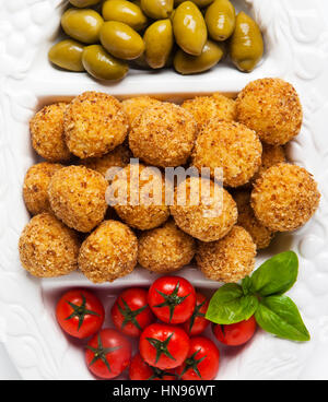 Gesunde italienische Vorspeise-Tablett mit Risotto Kugeln Arancini, grüne Oliven, Tomaten und Rotwein. Hochzeit Party Feier Stockfoto
