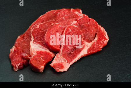 Frisches und rohes Fleisch. rohes Rindfleisch zum Kochen bereit. Hintergrund schwarz-Tafel Stockfoto