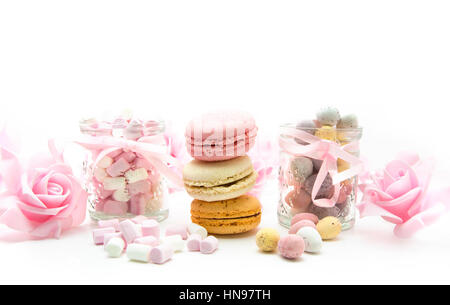 Ostern mit Eiern, Marhmallows, Makronen und rosa Rosen auf weißem Hintergrund behandelt Stockfoto