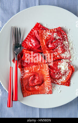 Ravioli Pasta mit Mozzarella, Basilikum und Parmesan auf blauem Hintergrund Stockfoto