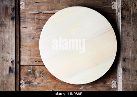 rundes Tablett aus Holz auf einem Holztisch. Pizza-Teller Stockfoto