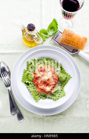 Schüssel mit italienisches Essen, Ravioli oder Tortelli auf dem Tisch. Käse und Wein. und Rotwein im Weinglas. Frühlingsstyle Stockfoto
