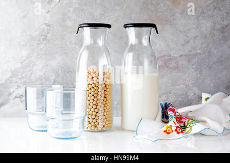 Soja-Milch in ein Glas und Soja trockene Bohnen. Vegane Milch. Gesunde Ernährung. Stockfoto