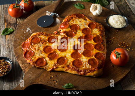 Hausgemachte herzförmige Peperoni-Pizza fertig zum Verzehr Stockfoto