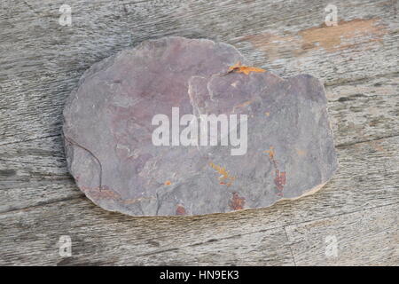 Flache rauer Stein auf einem Holztisch Stockfoto