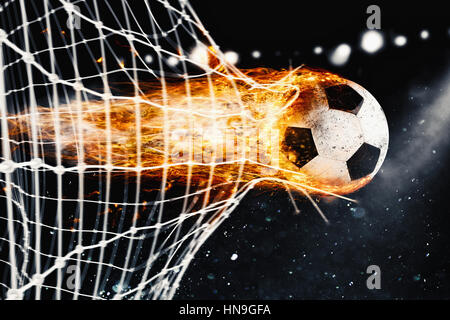 Fußball-Feuerball schießt ein Tor auf dem Netz Stockfoto
