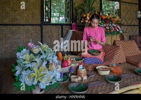 Thailändische Kunsthandwerkerin, die in einem thailändischen Kunst- und Kulturzentrum Essen modelliert. Thailand. Menschen In Südostasien Stockfoto