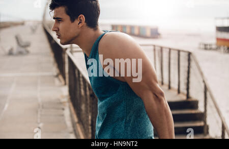 Seitenansicht erschossen Fit jungen Mannes im Freien stehen. Läufer, die Pause vom Training. Stockfoto