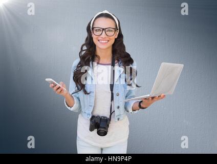 Digital Composite Frau mit Handy, Laptop und Kamera vor Marine Hintergrund mit flare Stockfoto