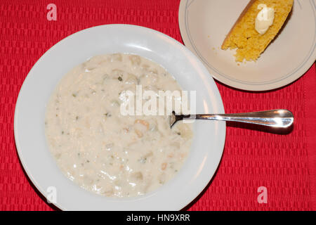 Eine Schüssel mit New England Muschelsuppe mit Maisbrot, auf eine rote Platzdeckchen. Von oben. Oklahoma, USA. Stockfoto