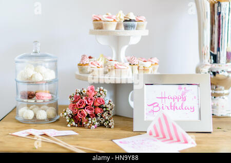 Alles Gute zum Geburtstag Grußkarte farblich passenden Blumenstrauß und cupcakes Stockfoto