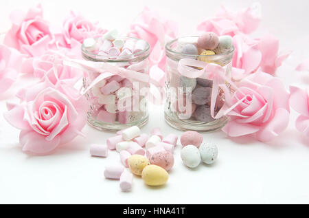 Ostern mit Mini-Eiern behandelt rosa Rosen und Marshmallows auf weißem Hintergrund Stockfoto