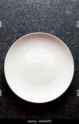 Leeren Teller auf schwarzem Marmor Stockfoto