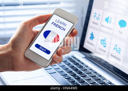 Lernen Sie Französisch Online-Konzept mit einer Person zeigt e-Learning-app auf dem Handy mit der Flagge von Frankreich Stockfoto