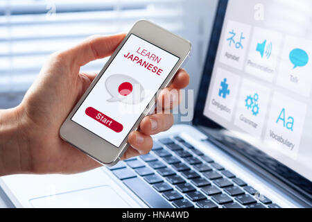 Lernen Sie Japanisch Online-Konzept mit einer Person zeigt e-Learning-app auf dem Handy mit der Flagge von Japan Stockfoto