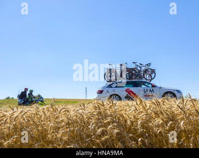 Saint-Quentin-Fallavier, Frankreich - 16. Juli 2016: die technischen Auto IAM Cycling Team und ein Werksmotorrad fahren in einem Weizen schlicht in der Phase 1 Stockfoto