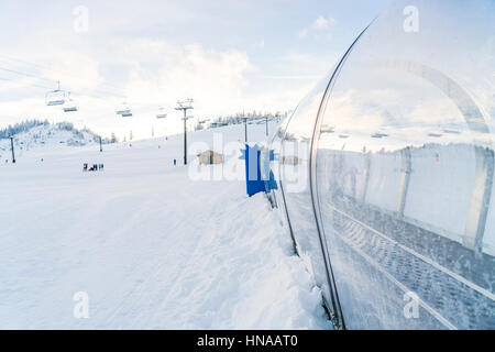 Teppich-Aufzug im Skigebiet mit Schnee Gebirgshintergrund. Stockfoto