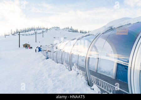 Teppich-Aufzug im Skigebiet mit Schnee Gebirgshintergrund. Stockfoto