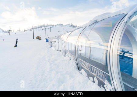 Teppich-Aufzug im Skigebiet mit Schnee Gebirgshintergrund. Stockfoto