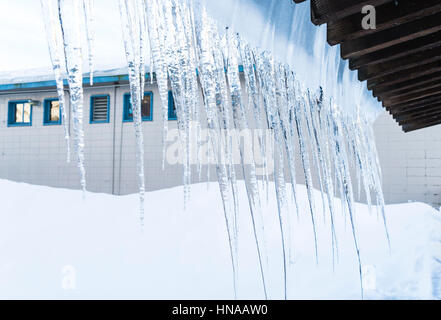 Eiszapfen hängen von einem Dach Stockfoto