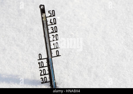 Thermometer auf Schnee zeigt niedrige Temperaturen unter Null in Grad Celsius Stockfoto