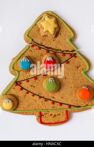 Gebrochen großen Iced Gingerbread Christmas Tree Biskuit mit süßen Kugeln verziert und Eistee Sterne Set auf weißem Hintergrund Stockfoto