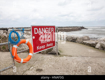 Warnschild am Hafen am Staithes, North Yorkshire Steinschlag Stockfoto