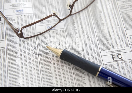 Kugelschreiber Und Lesebrille Stück Auf Boerseteil Einer Zeitung - Finanzmarkt in Zeitung Stockfoto