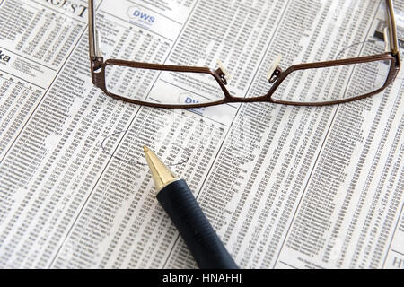 Kugelschreiber Und Lesebrille Stück Auf Boerseteil Einer Zeitung - Finanzmarkt in Zeitung Stockfoto