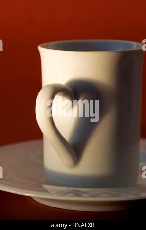 Henkel Einer Kaffeetasse Wirft Herzfoermigen Schatten - Griff für eine Kaffeetasse macht einen Herz-Schatten Stockfoto