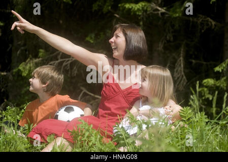 Mutter Sitzt Mit Sohn Und Tochter in der Wiese - Mutter mit Sohn und Tochter Stockfoto