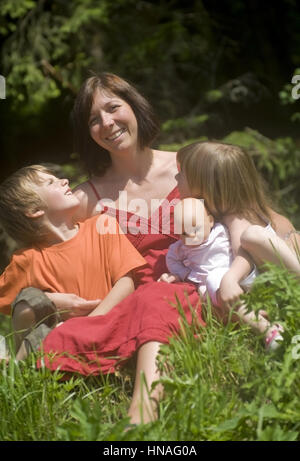 Mutter Sitzt Mit Sohn Und Tochter in der Wiese - Mutter mit Sohn und Tochter Stockfoto