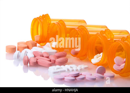 Fünf Flaschen Rezept aufgereiht auf ihren Seiten verschütten Medikamente Pillen heraus auf einer reflektierenden Oberfläche isoliert auf einem weißen Hintergrund. Darstellung von mu Stockfoto