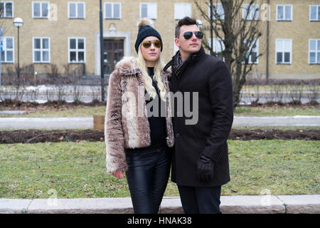 Paar schöne kaukasischen Mode. Frau in GAP und einen Pelzmantel. Mann in Handschuhe. Schwedische skandinavischer Herkunft. Winter- und outdoor im Stadtbild. Stockfoto