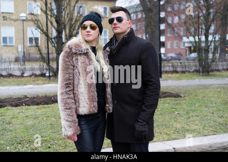 Paar schöne kaukasischen Mode. Frau in GAP und einen Pelzmantel. Mann in Handschuhe. Schwedische skandinavischer Herkunft. Winter- und outdoor im Stadtbild. Stockfoto