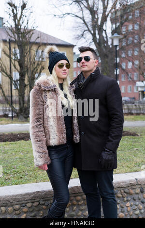 Paar schöne kaukasischen Mode. Frau in GAP und einen Pelzmantel. Mann in Handschuhe. Schwedische skandinavischer Herkunft. Winter- und outdoor im Stadtbild. Stockfoto