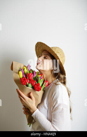 Feminine schöne Mädchen einen Blumenstrauß in den Händen, Augen geschlossen halten Stockfoto